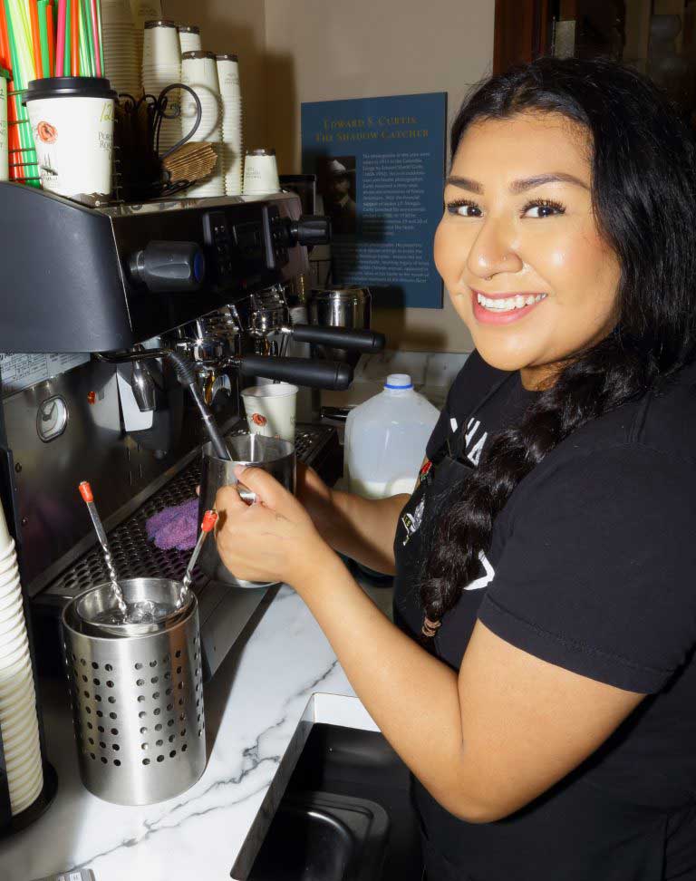 Image of a smiling woman making coffee at the Vista House.